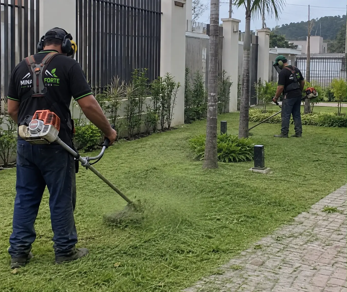 Profissionais da Minas Forte realizando acabamento de área verde em condomínio.